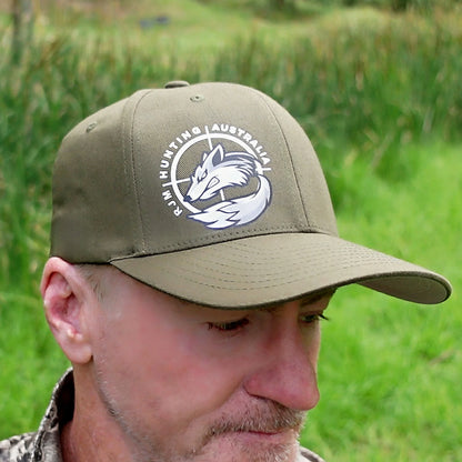 Close-up of an olive RJM Hunting Australia Flexfit cap with the white fox logo on the front
